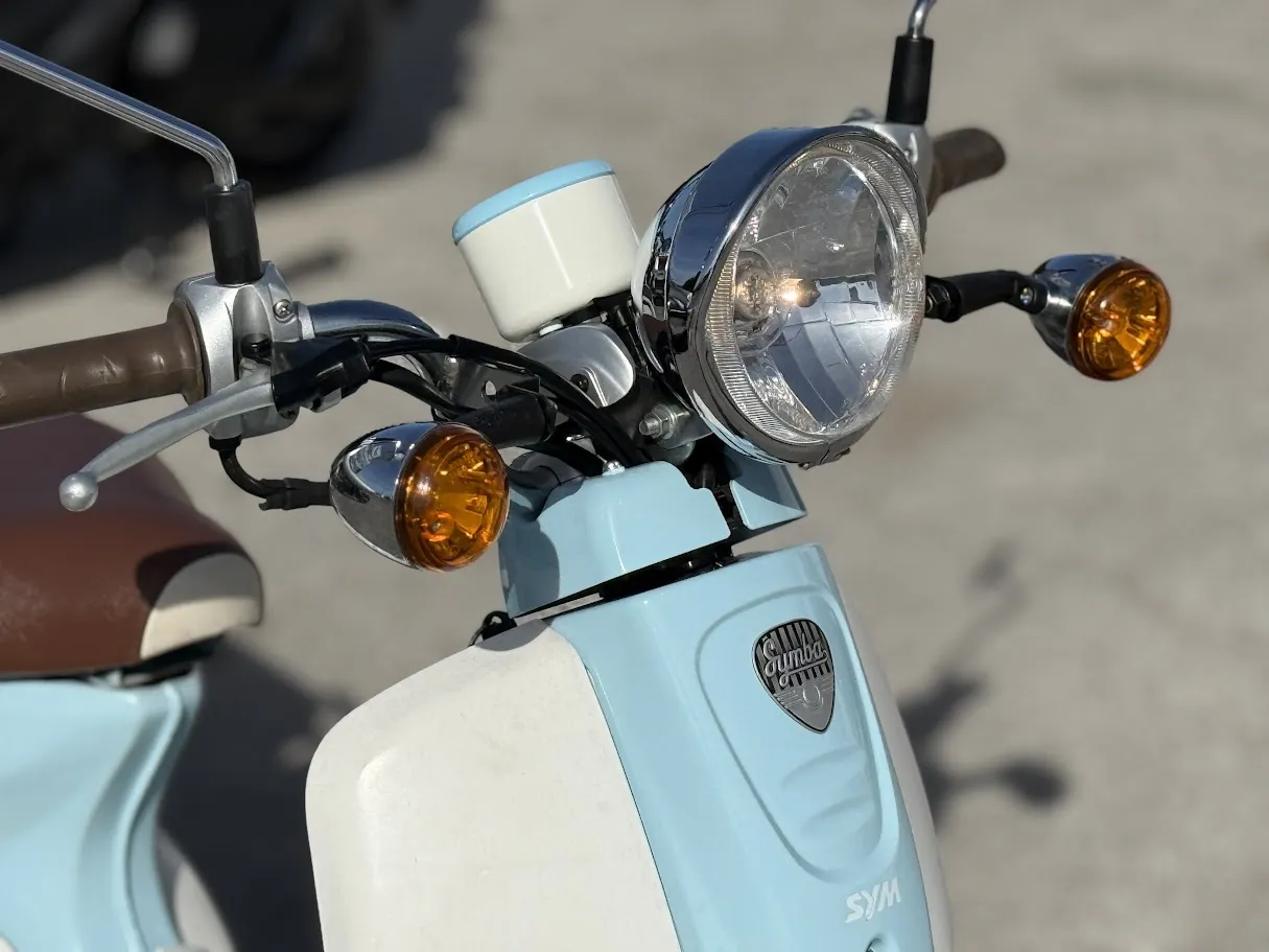 Used 2015 SYM Symba 110 in stock color, side profile, at The Motorcycle Shop San Antonio